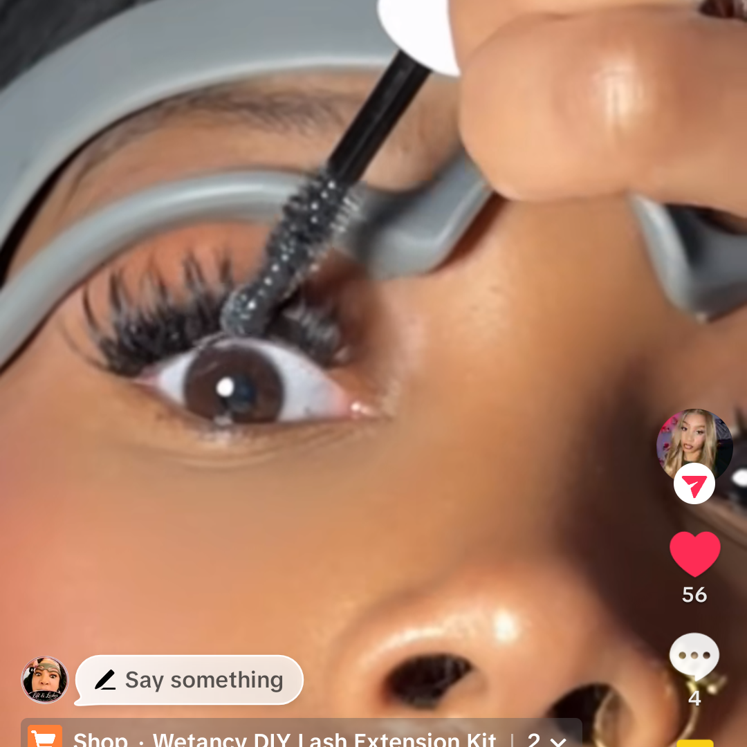 A close-up social media story showing a hand applying false eyelashes with a lash applicator to a person's eye. The story includes the text 'diylashexextensions' at the top, a search bar, and the profile name 'Rybbaby | Hair, Beauty, & DIY' in the comments section.